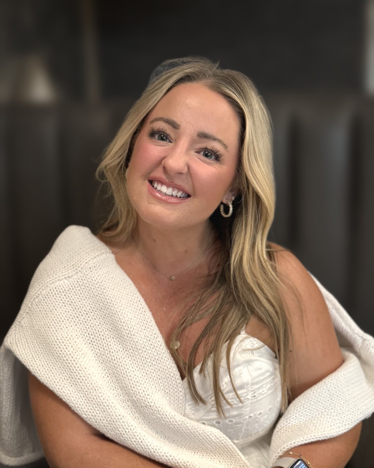 Katy Sears, founder of MK Collective, smiling in a white knit sweater